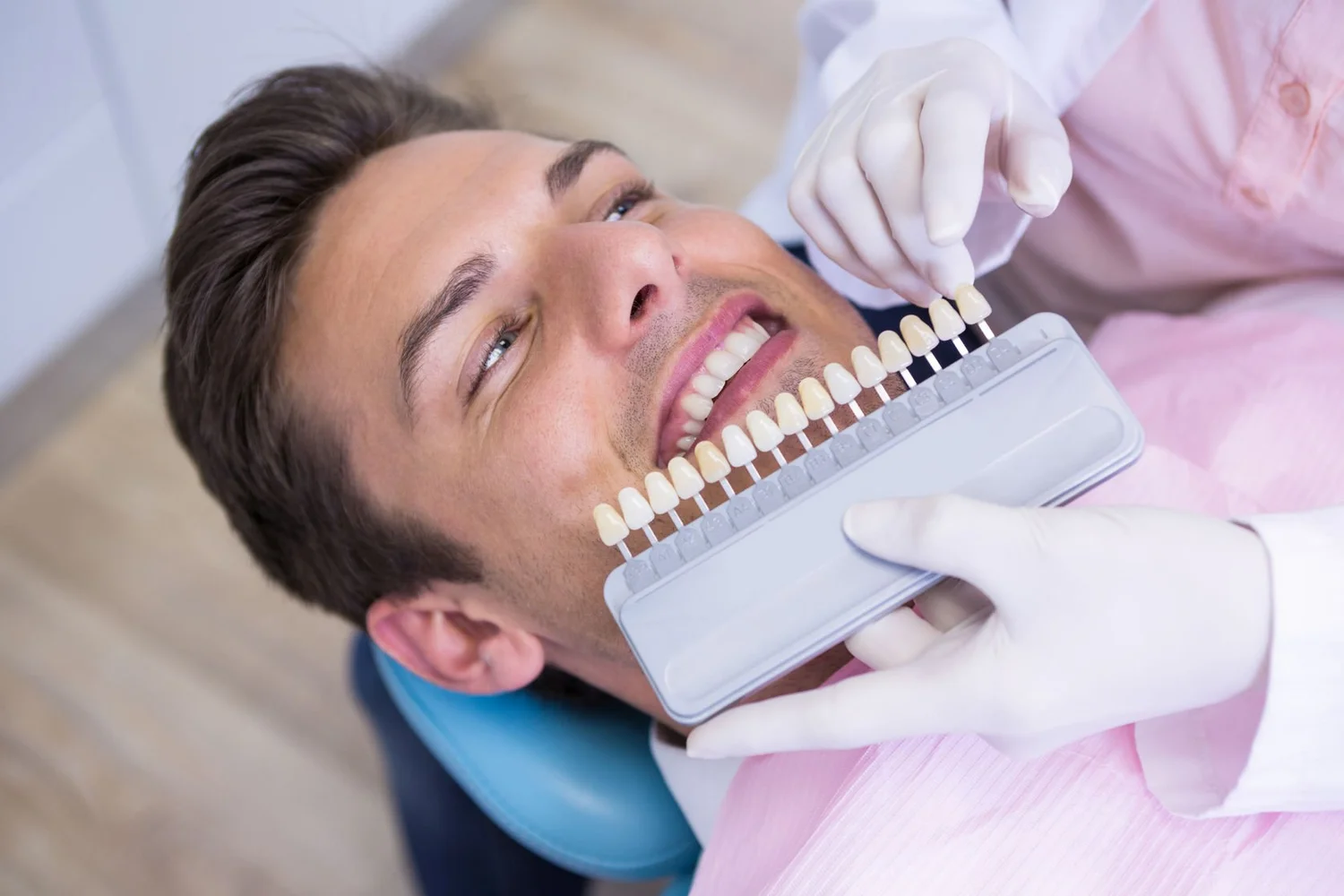 Dentist matching tooth shade for a cosmetic treatment at Health Sense Dental in Shorewood