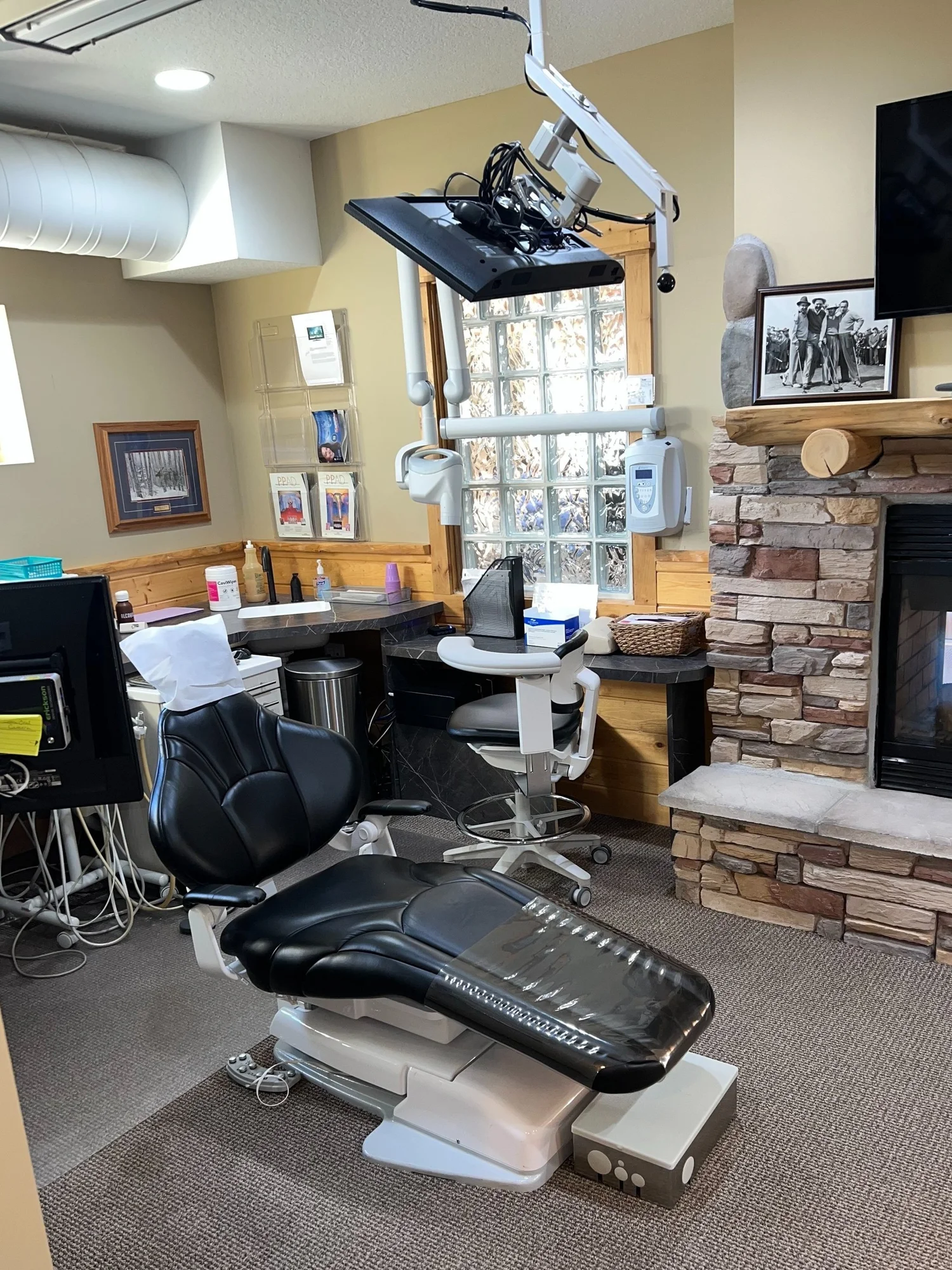 Cozy Health Sense Dental treatment room with a stone fireplace, log-cabin woodwork and modern dental chair